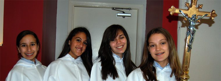 4 young adult females prepare to serve Mass smiling at the Camera